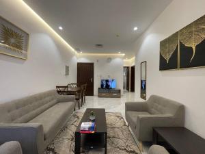Golden Dahlia Fintas في الكويت: غرفة معيشة مع كنب وغرفة طعام