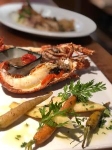 a plate of food with vegetables on a table at Hôtel Le Porquerollais in Porquerolles