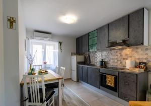a kitchen with a table and a stove top oven at Apartman Tina in Metković