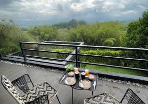 a table with food and drinks on a balcony at Panorama Pueblo Tapao by DOT Boutique in Armenia