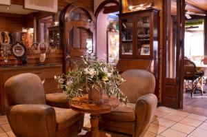 a room with chairs and a table with flowers on it at Hôtel Le Porquerollais in Porquerolles