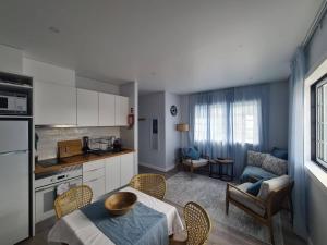 a kitchen and living room with a table and chairs at A Casa da Areia Larga in Madalena
