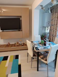 a dining room with a table and chairs and a television at ally apartament in Constanţa