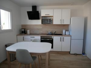 uma cozinha com uma mesa branca e um frigorífico branco em Appartement lumineux au calme em La Roche-sur-Yon