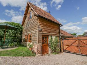 een klein houten huis met een hek en een hek bij The Forge in Hereford
