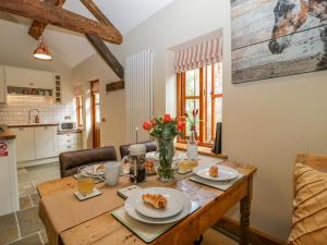 een keuken en eetkamer met een houten tafel bij The Forge in Hereford