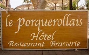 a sign for a hotel restaurant in front of a building at Hôtel Le Porquerollais in Porquerolles