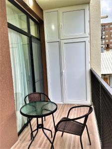 uma mesa de pátio e 2 cadeiras numa varanda em Apartment D. Digomi em Tbilisi