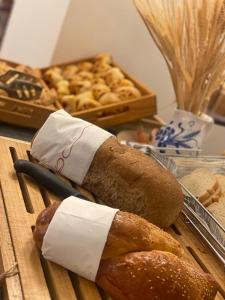 a table topped with bread and a cutting board with pastries at Hotel Apogeo in Rimini