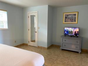 a bedroom with a bed and a television on a dresser at Hideaways Exuma in Georgetown