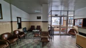 a waiting room with brown leather chairs and a table at Hotel Bela Vista in Viseu