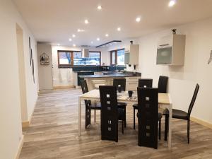 a kitchen and dining room with a table and chairs at Chalet les Vagnys - Lac des Vernays in La Rivière-Enverse