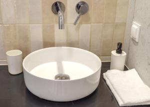 a white sink in a bathroom with aaucet at Apartament Piaskowy in Chmielno +11 photos
