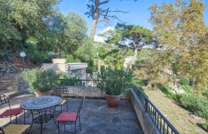 un patio con mesa, sillas y árboles en Villa A Ventosa en Bastia