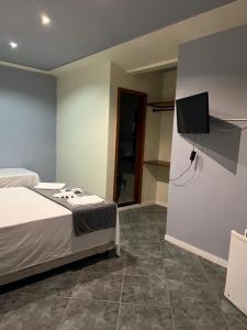 Una cama o camas en una habitación de Tortuguita Ossos - Suítes