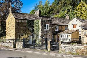 an old stone house with an iron gate at The Belle - A lovingly converted Grade II Listed home from home in Bakewell in Bakewell