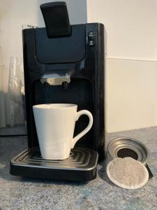 eine Kaffeemaschine mit einer Tasse auf der Theke in der Unterkunft APPART'AGEN in Agen