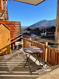 a chair on a balcony with a view of mountains at Front neige 1800, cosy 4-6p, parking couvert in Les Orres