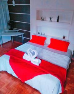 1 dormitorio con 1 cama grande con sábanas rojas y blancas en Pousada Jupter en Teresópolis