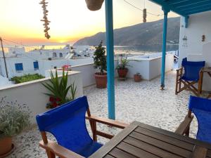 a table and chairs on a balcony with a view of the ocean at Aegeon Pension in Aegiali