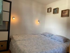 a bedroom with a bed and two lights on the wall at Front neige 1800, cosy 4-6p, parking couvert in Les Orres
