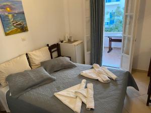 a bedroom with a bed with two towels on it at Aegeon Pension in Aegiali