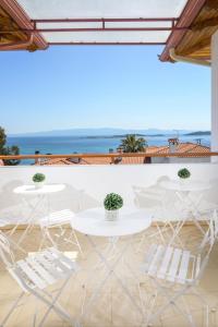 a view of two white tables and chairs on a balcony at PENSION STELIOS in Ouranoupoli
