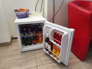 a small white refrigerator filled with lots of drinks at chez moumie jacuzzi privatif in Bevaix