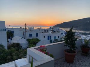 a view of a town at sunset from a house at Aegeon Pension in Aegiali
