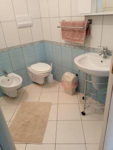 a bathroom with a toilet and a sink at Marvi's Gated Beach area apt in Durrës +22 photos