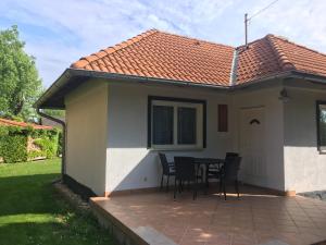 a small house with a table and chairs on a patio at KATÓ APARTMAN in Siófok