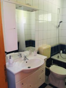 a bathroom with a sink and a toilet and a mirror at KATÓ APARTMAN in Siófok