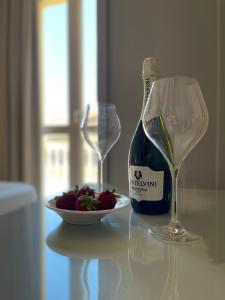 a bottle of wine and a plate of strawberries on a table at Terrazzo Del Borgo in Tropea