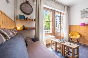 un soggiorno con un divano blu e un tavolo di Cosy 40m With Balcony In The Heart Of Chamonix a Chamonix-Mont-Blanc