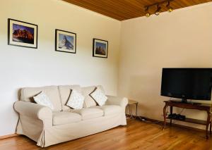 a living room with a white couch and a flat screen tv at Enjoy Hiking in Aufseß