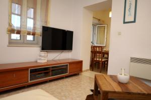 a living room with a flat screen tv on a entertainment center at Apartment Lea in Pučišća