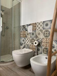 a bathroom with a tub and a toilet and a sink at Terrazzo Del Borgo in Tropea
