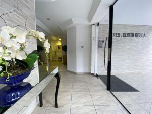 a hallway with a vase of flowers on a table at CB62 - Duplex, 4 Dorm Climatizados, Churrasqueira in Balneário Camboriú