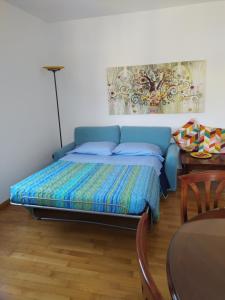 a blue bed in a room with a table at Appartamento Clary in Montecatini Terme