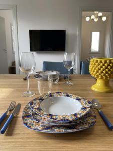 una mesa con un plato y copas de vino. en Marosa Casa Vacanze, en Torretta