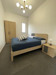 1 dormitorio con 1 cama grande con manta azul en Marosa Casa Vacanze, en Torretta