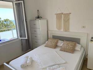 1 dormitorio con 1 cama con 2 almohadas y ventana en Spile Rooms Lukas, en Himare