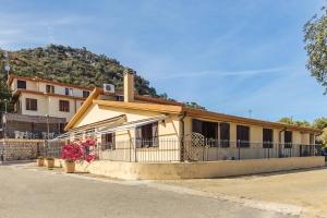 Un edificio con una valla y flores delante. en Ostello Bellavista, en Santa Maria Navarrese