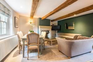 a living room with a table and chairs and a couch at The Aubrey - a gorgeous converted 17th Century Grade II listed bolthole in Bakewell in Bakewell +15 photos