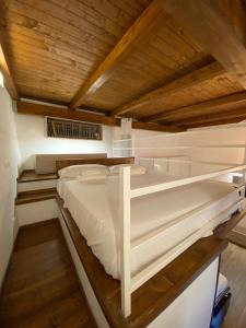 a white bed in a room with a wooden ceiling at Da Sepideh in Gaeta
