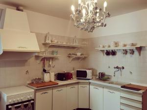 a kitchen with white cabinets and a chandelier at Appartamento Ca' Di Nive in Venice