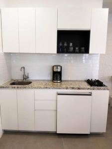 a kitchen with white cabinets and a counter with a sink at Studio Pulpito in the charming heart of downtown PV in Puerto Vallarta