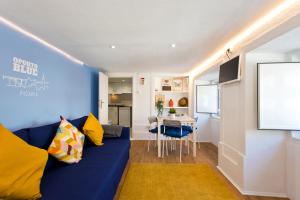 uma sala de estar com um sofá azul e uma mesa em Oporto Blue Picaria - Unique Citycenter Apartment no Porto