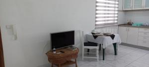 a kitchen with a table and a television and a table and chair at Ka-Bela 2 in Sal Rei