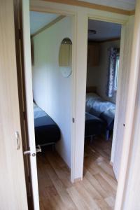 een kamer met een slaapkamer met 2 bedden en een spiegel bij Landbouwlust Chalet Melrose in Serooskerke